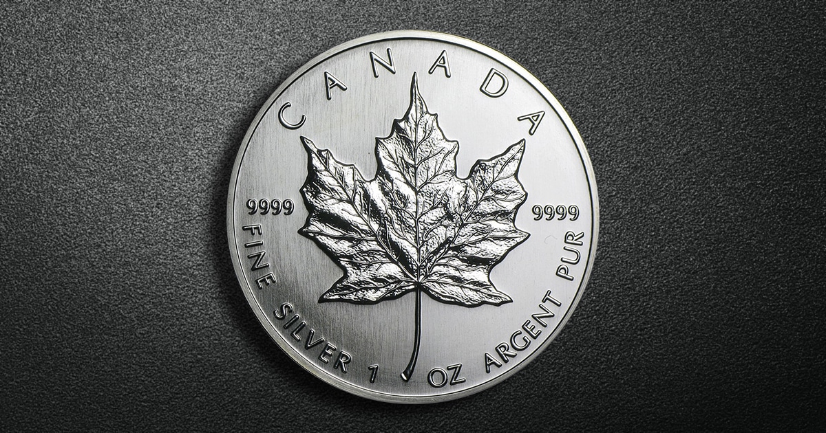 A Brilliant Uncirculated Canadian Silver Maple Leaf against a patterned background.