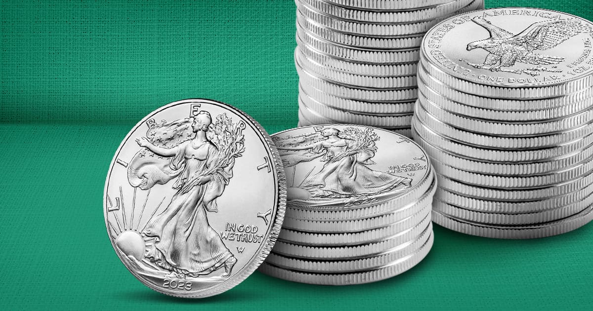 One Silver American Eagle rests against three stacks of American Silver Eagles.