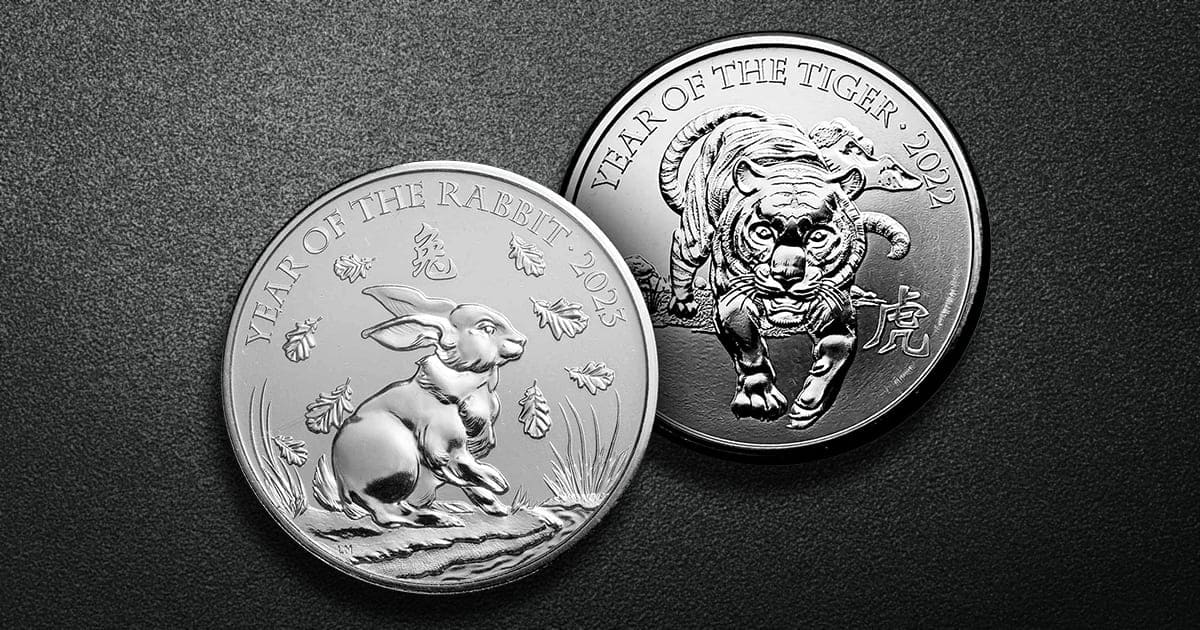 Two silver British Lunar series coins atop a textured background