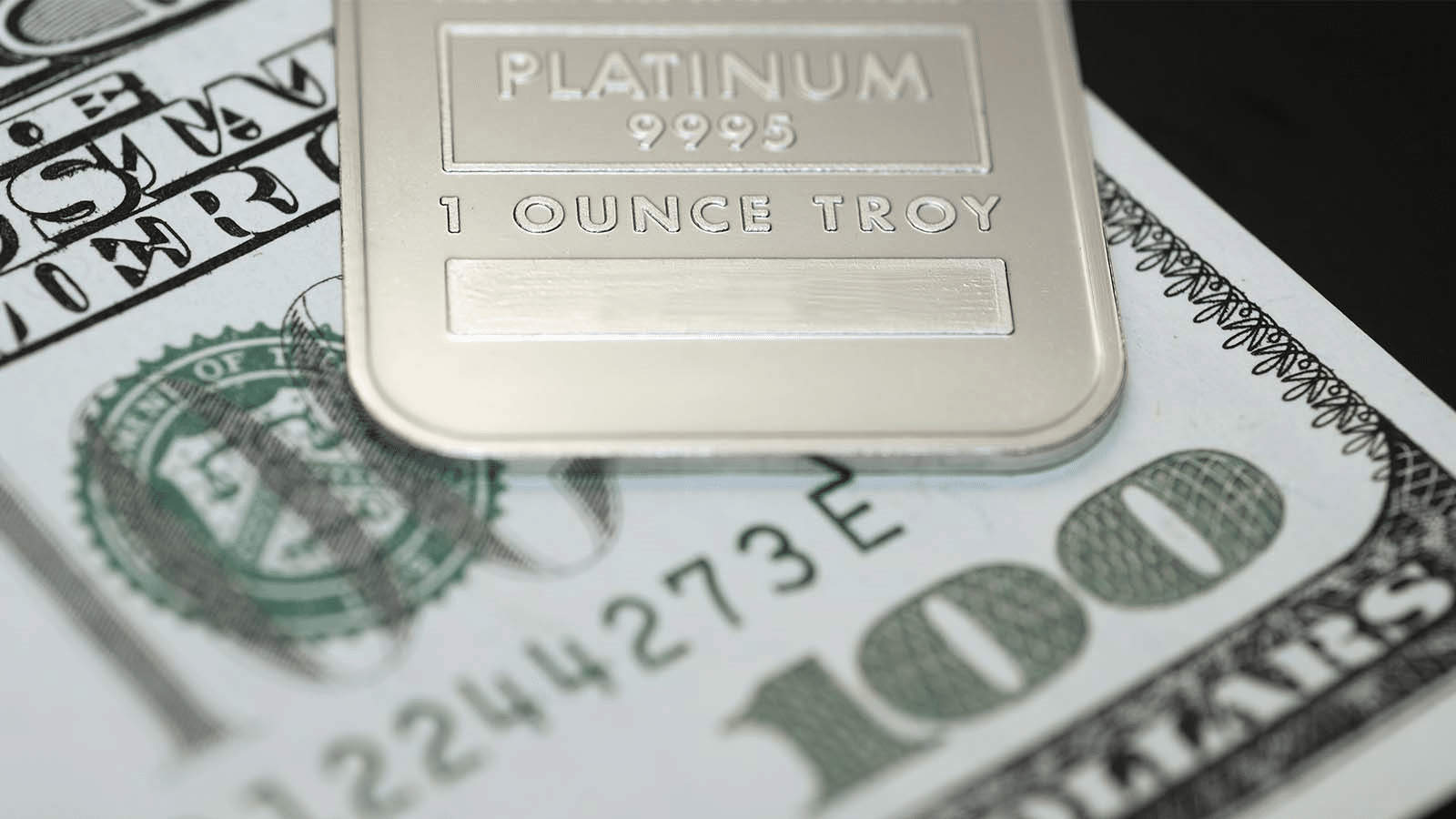 One troy ounce bar of platinum and a $100 bill.