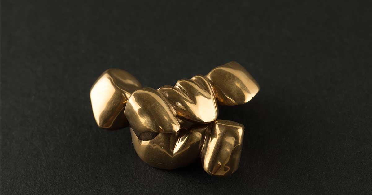 Gold grillz on a black mat.