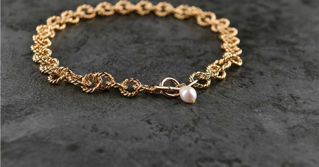 A gold bracelet on a table.