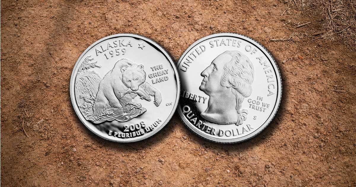 Two Alaska state quarters on the dirt.