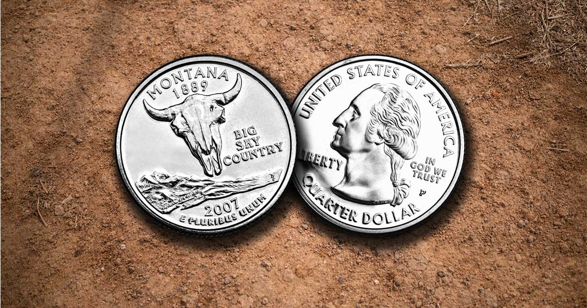 Two Montana state quarters sit in the dirt.